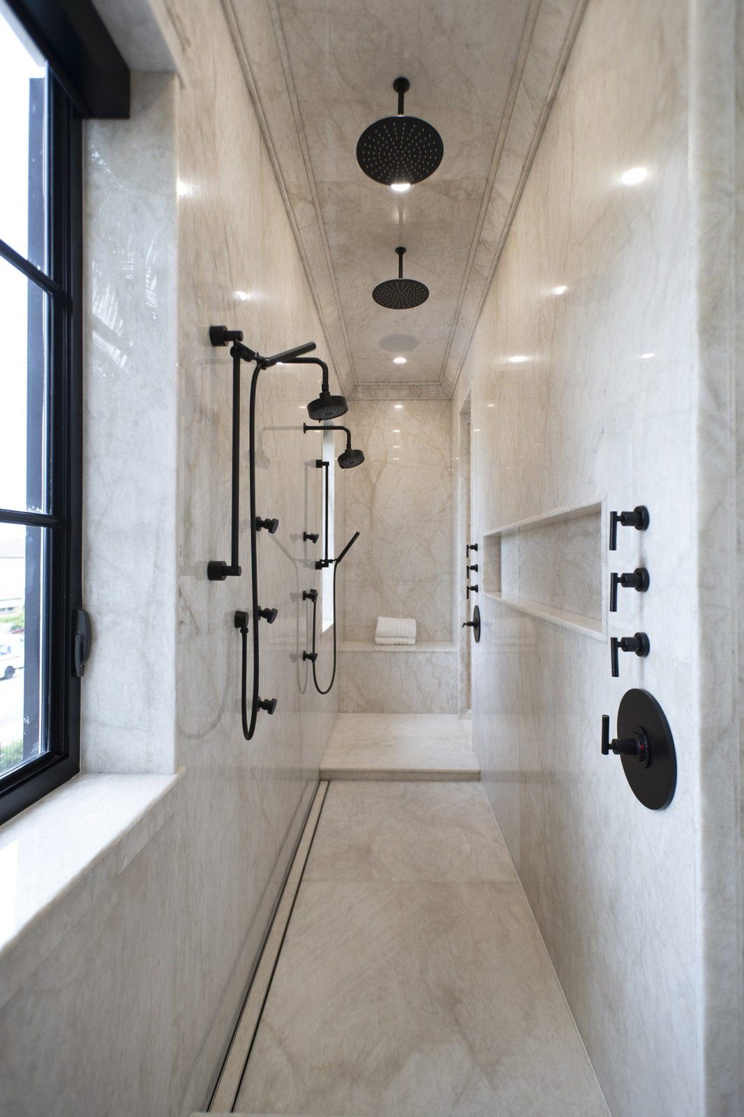 Cristallo Cristallo quartzite lining a walk-in shower, from walls and bench to floor